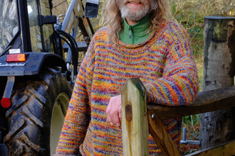 Rob standing next to a tractor holding wire