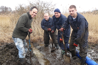 A group of friends dig in the mud