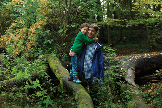 Father and son standing on a tree branch