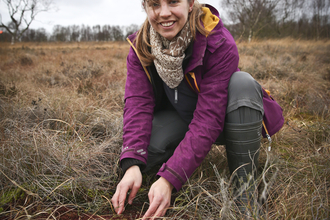 Elspeth holding soil in a wetland