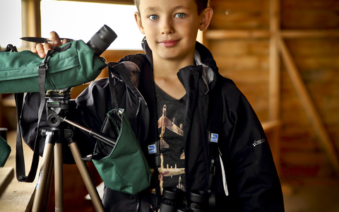 Ben in a bird hide with a telescope