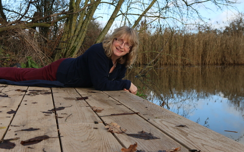 Nicky sits on the edge of a lake