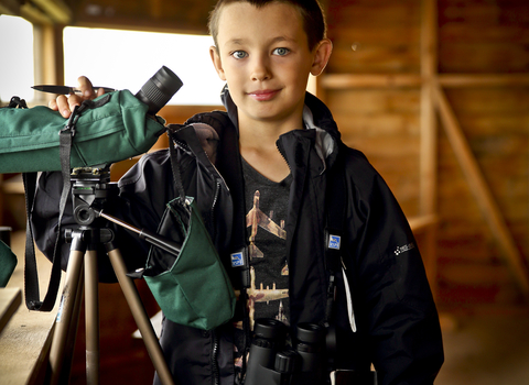 Ben in a bird hide with a telescope