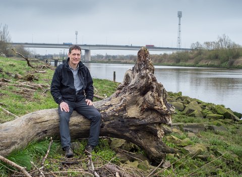 Jeremy sat on a log next to a river