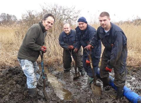 A group of friends dig in the mud